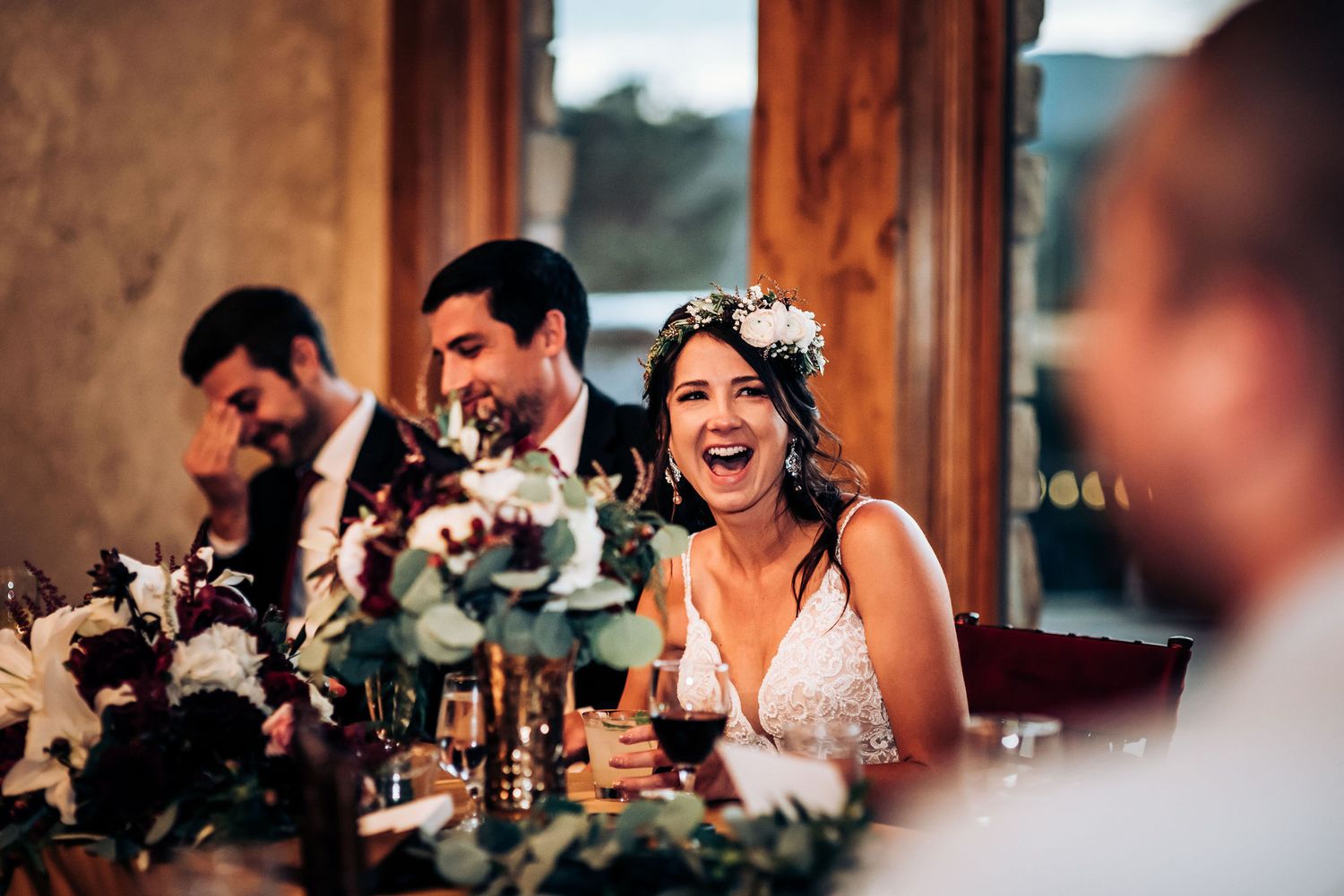 Candid moment during wedding reception with floral table decorations.