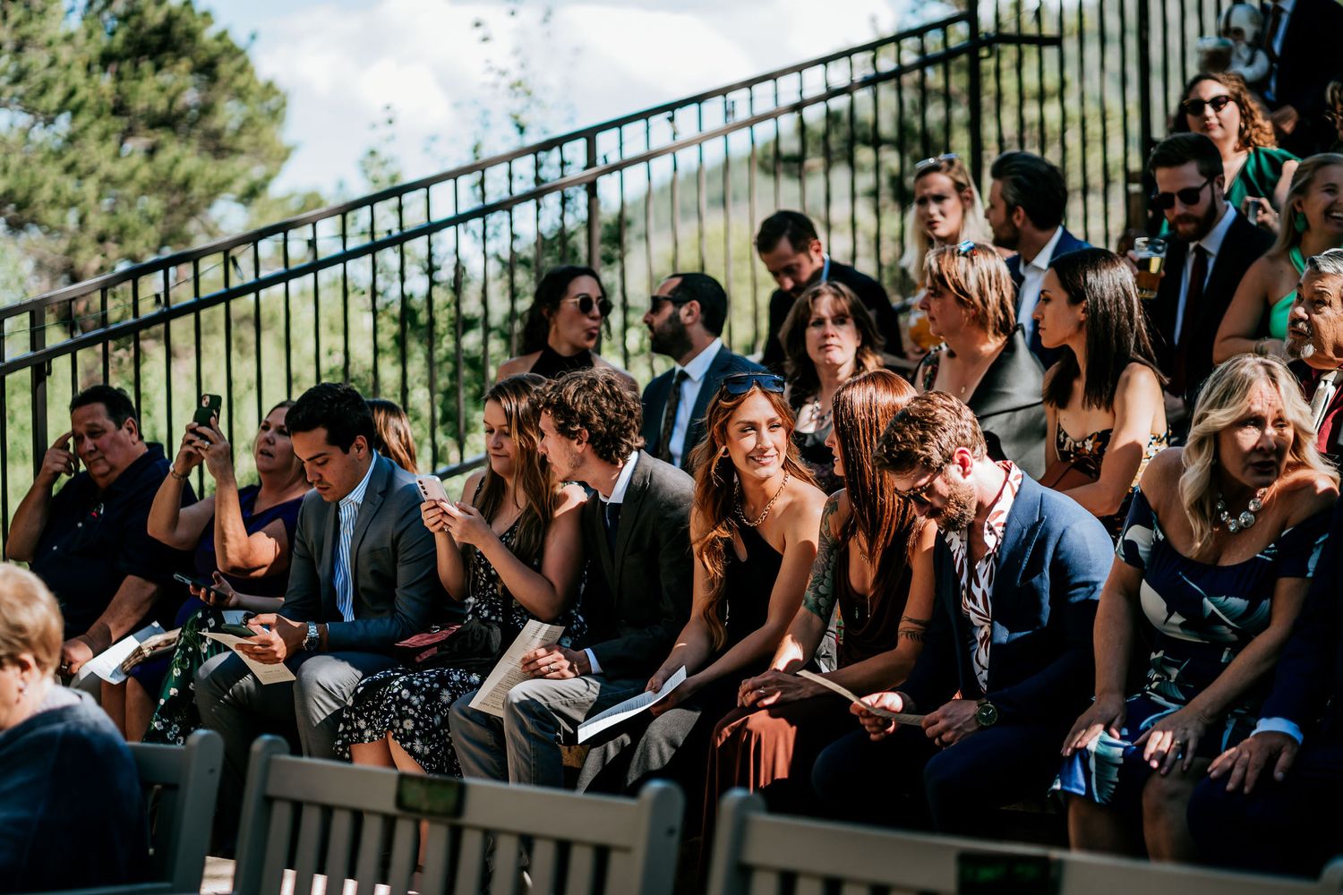 Wedding guests seated on tiered outdoor seating sharing emotional moments together.