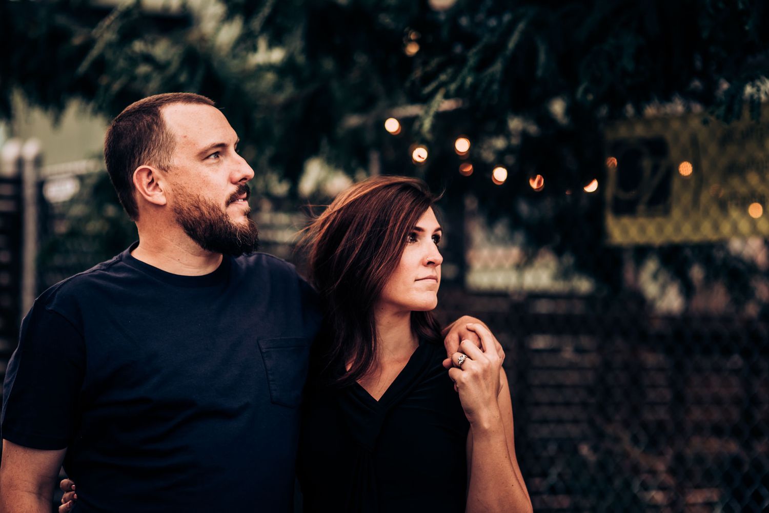 Romantic couple posing together outdoors at dusk.