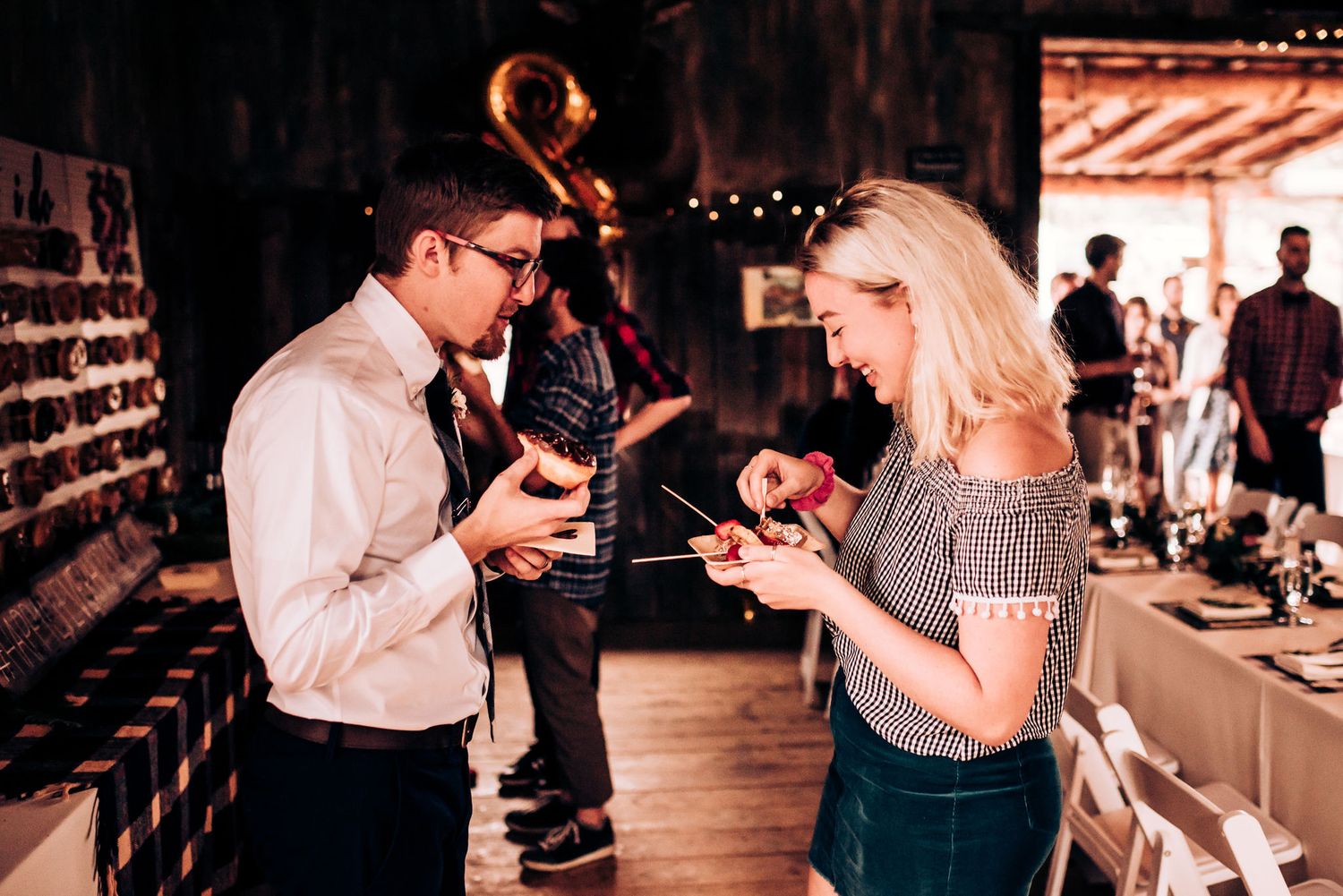 Wedding guests interacting at an indoor rustic venue during reception.