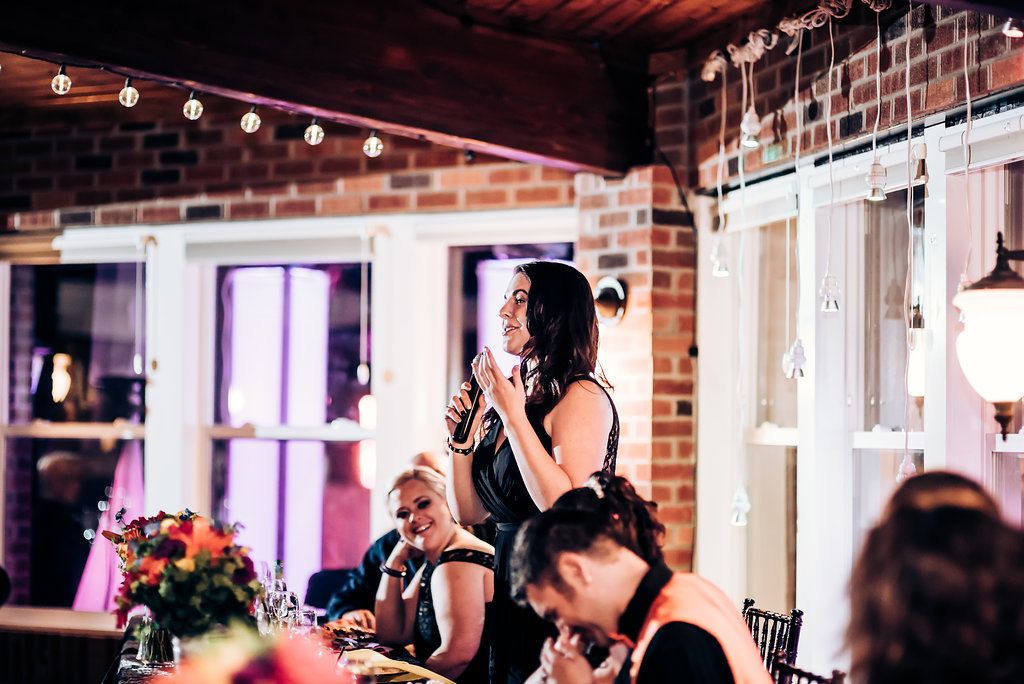 Reception venue with exposed brick walls and string lights during evening celebration.
