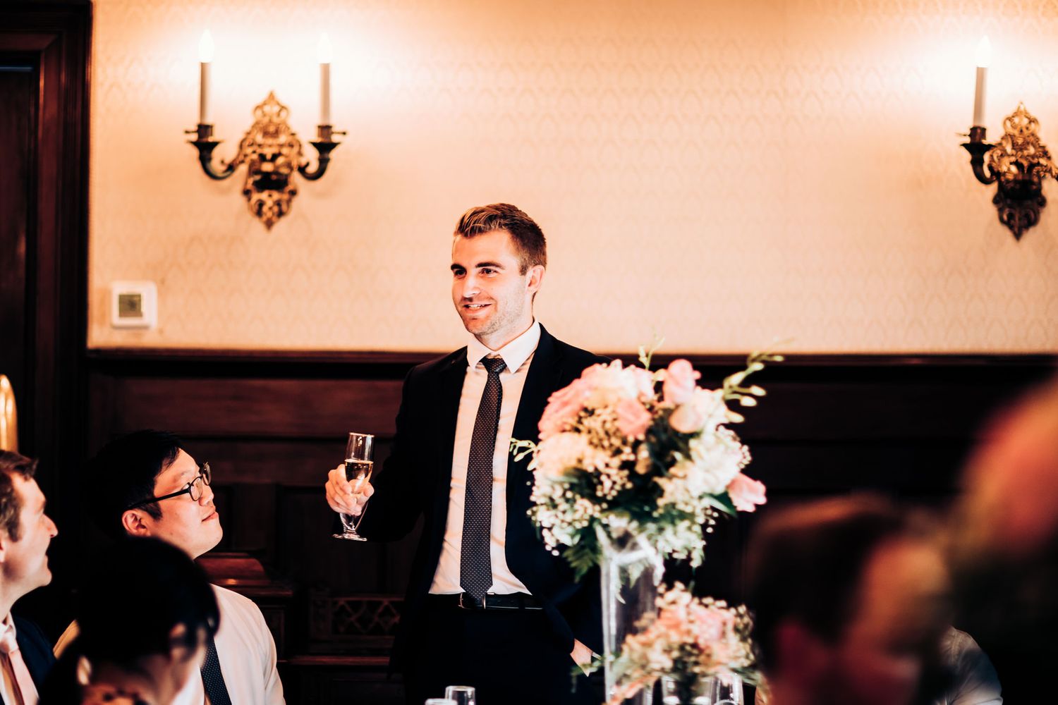 A celebratory scene at an elegant wedding reception with candelabras and floral centerpieces.