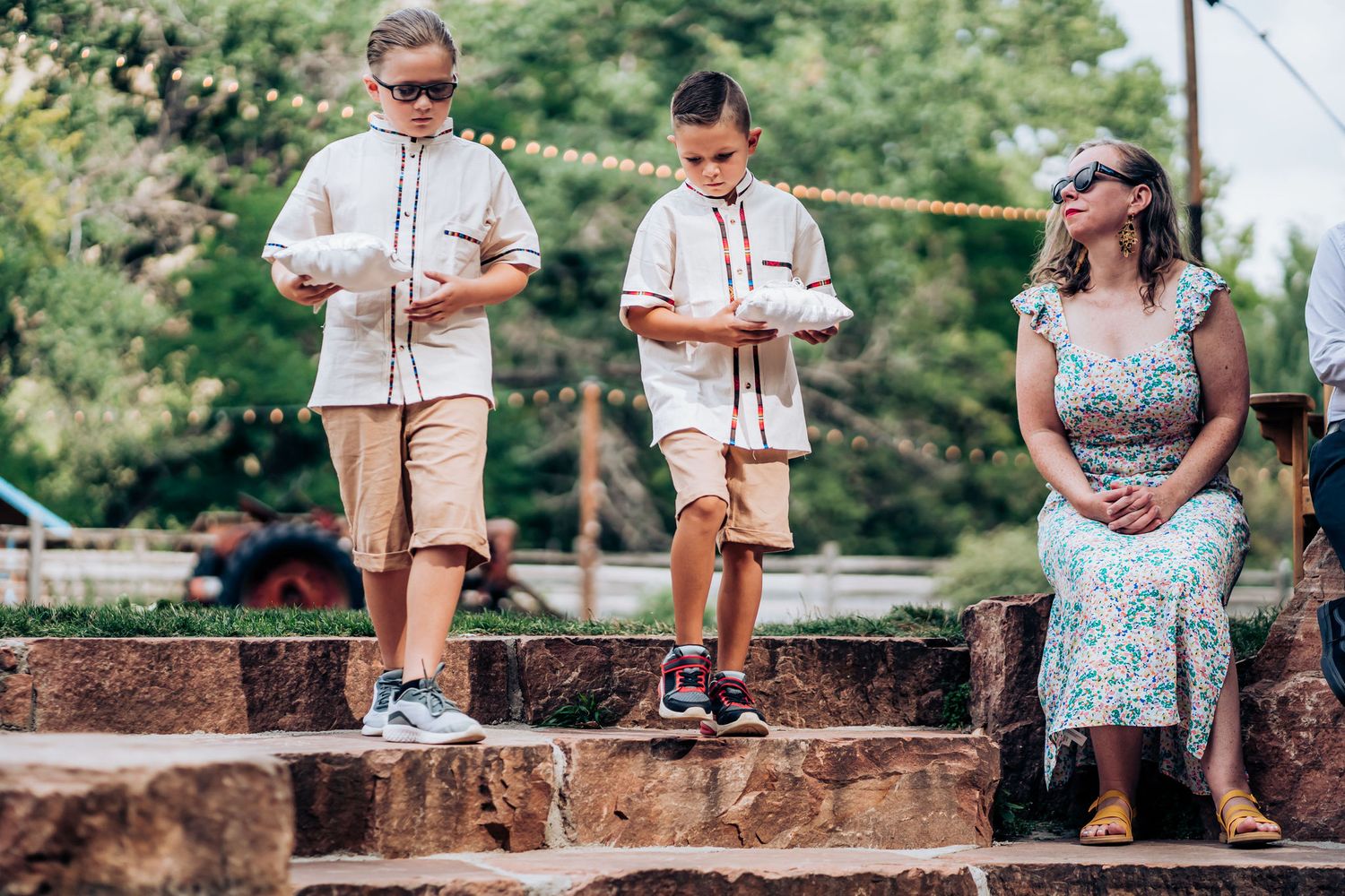 Young guests stand on stone steps during an outdoor ceremony.