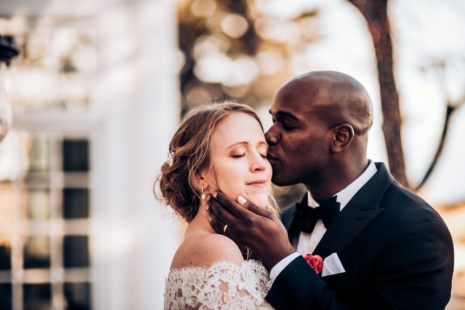 Romantic moment between newlyweds sharing a tender kiss during their wedding ceremony.