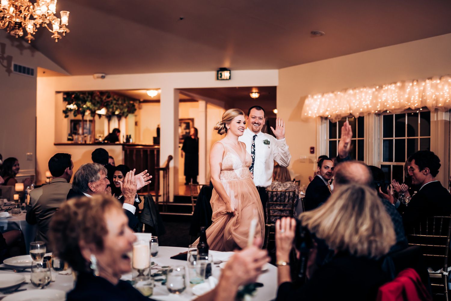 Wedding reception venue with guests clapping during celebration.