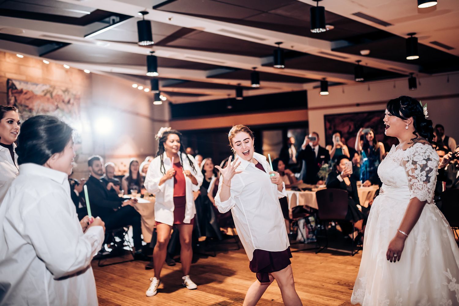 Wedding celebration with dancers performing in white outfits while guests watch from the sidelines.