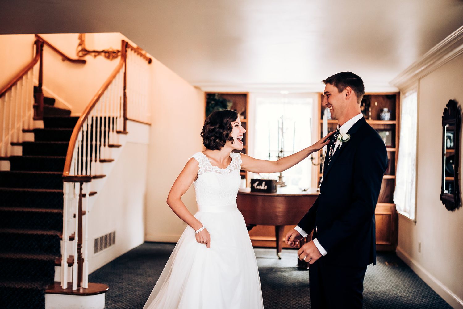 A candid first look moment between newlyweds in an elegant indoor setting.