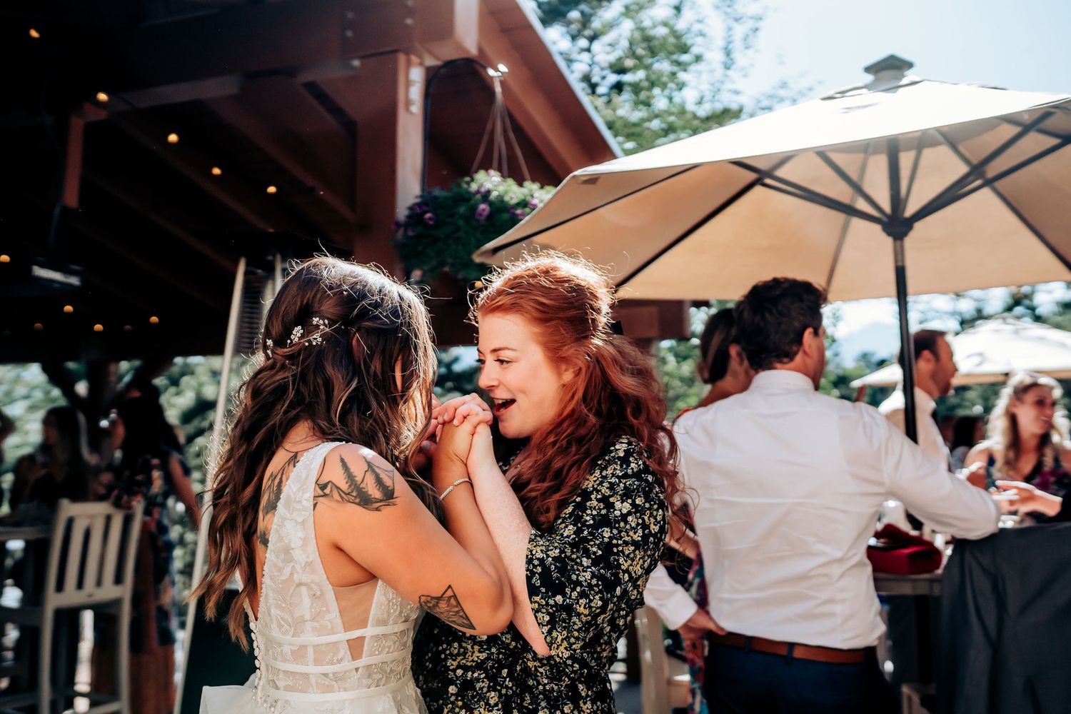Joyful dancing and celebration at outdoor wedding reception under market umbrellas.