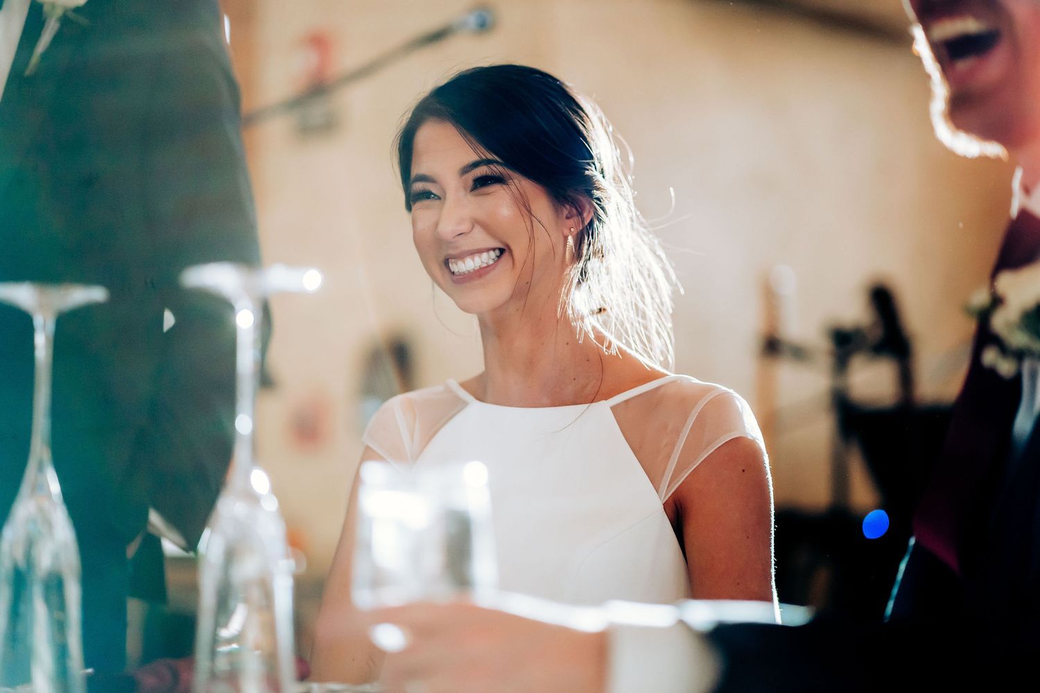 Candid moment of bride smiling during wedding reception festivities.