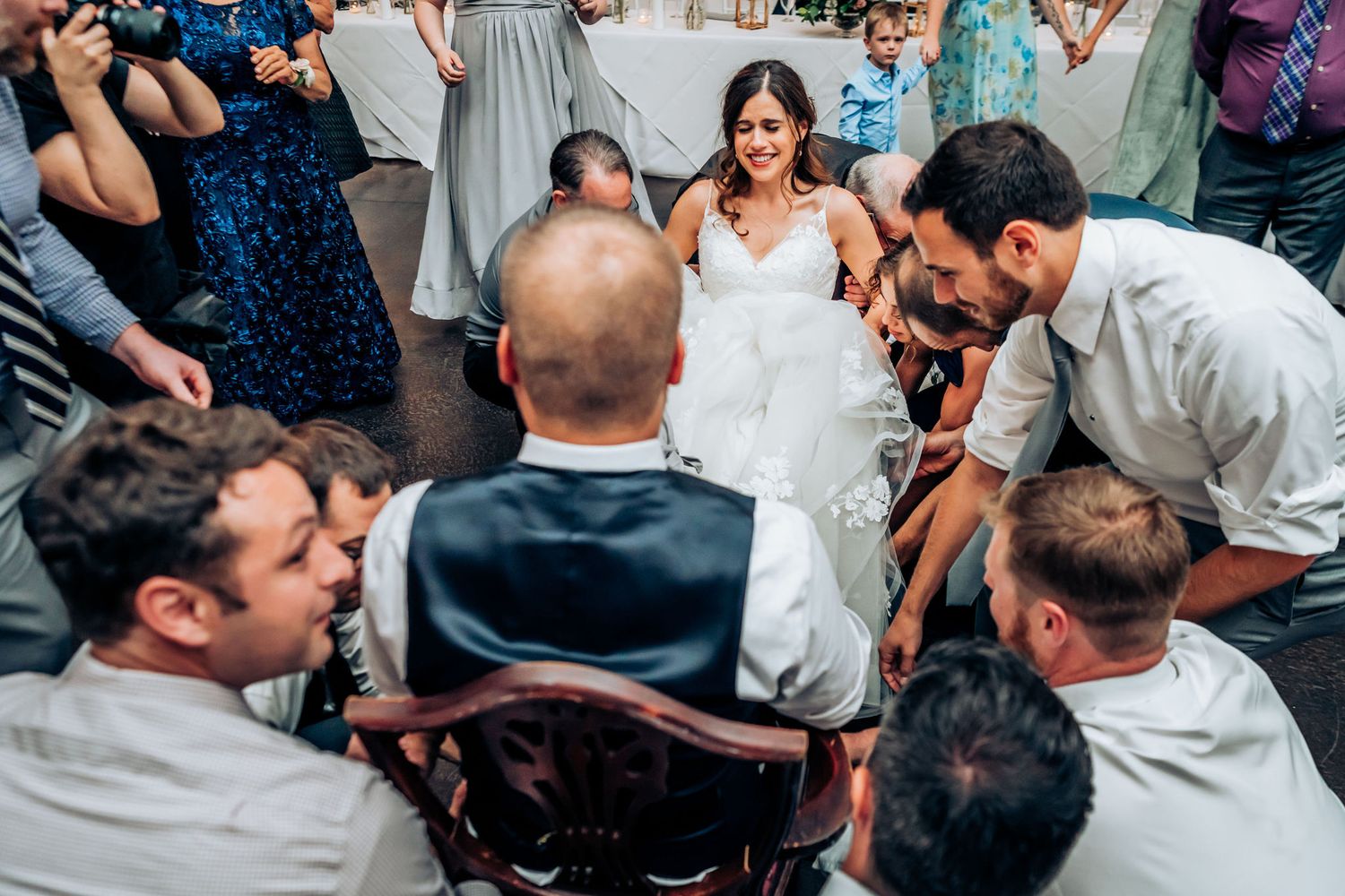 Wedding guests gather in a circle on the dance floor during celebration festivities.