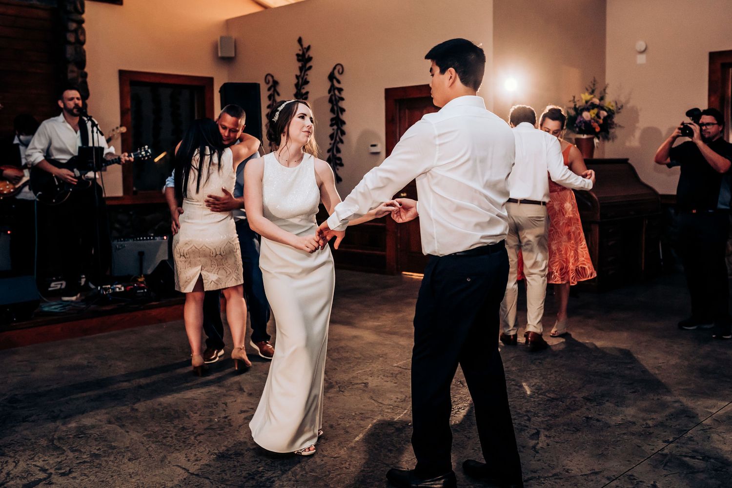 Couple dances together during their wedding reception surrounded by guests.