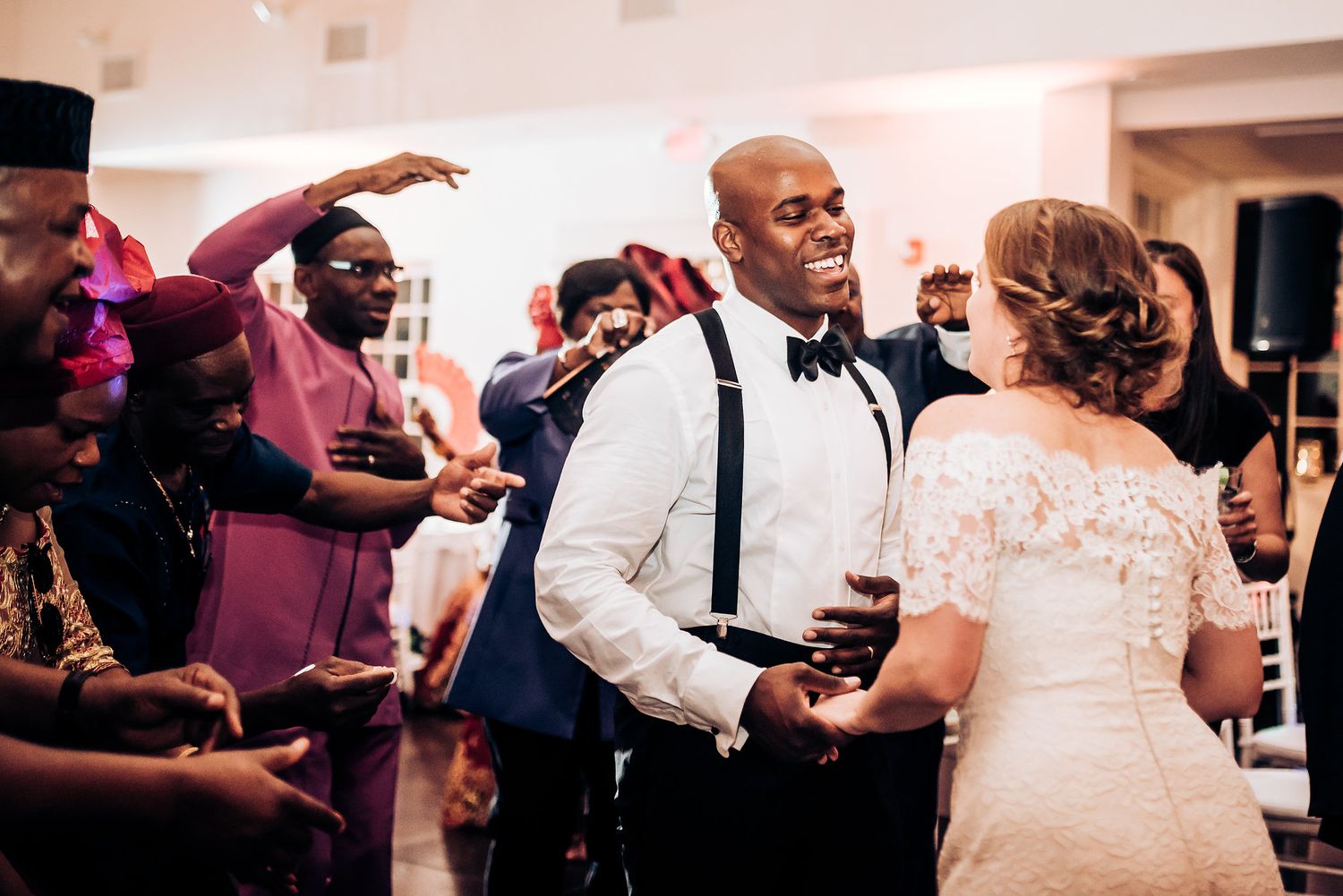 Guests create a dance circle during a joyous wedding reception celebration.