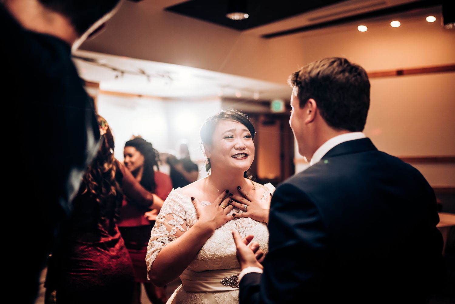 Joyful interaction between guests during indoor celebration event.