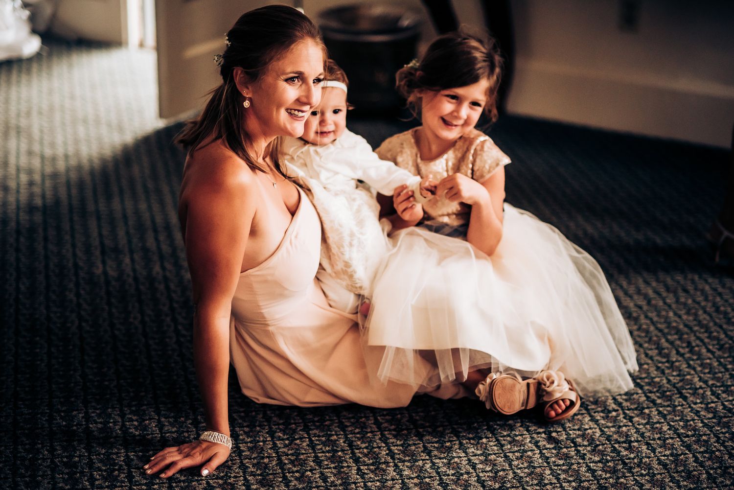 Joyful moment shared on carpeted floor with formal attire.