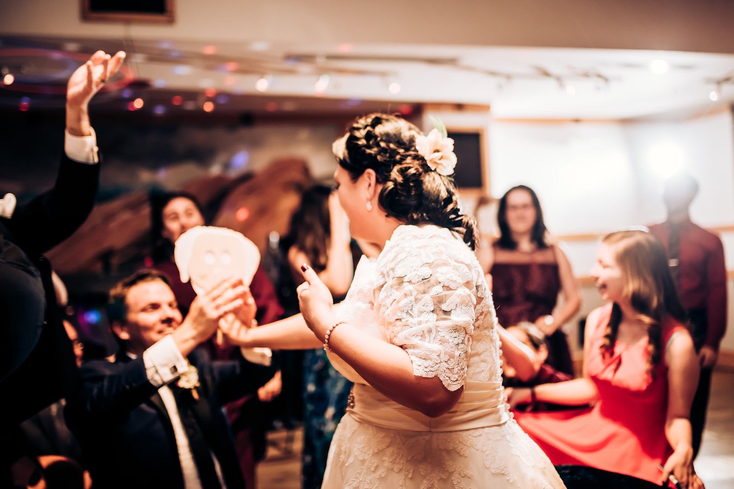 A lively wedding reception dance floor with guests in formal attire celebrating.