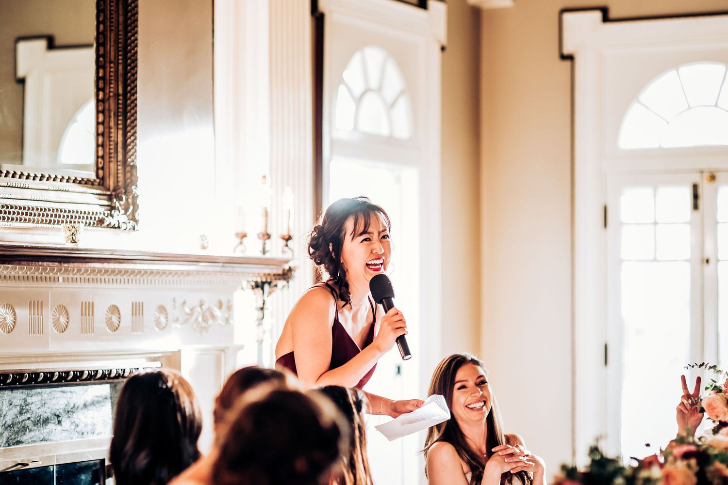 Toast being given during elegant dinner reception with ornate architectural details visible.