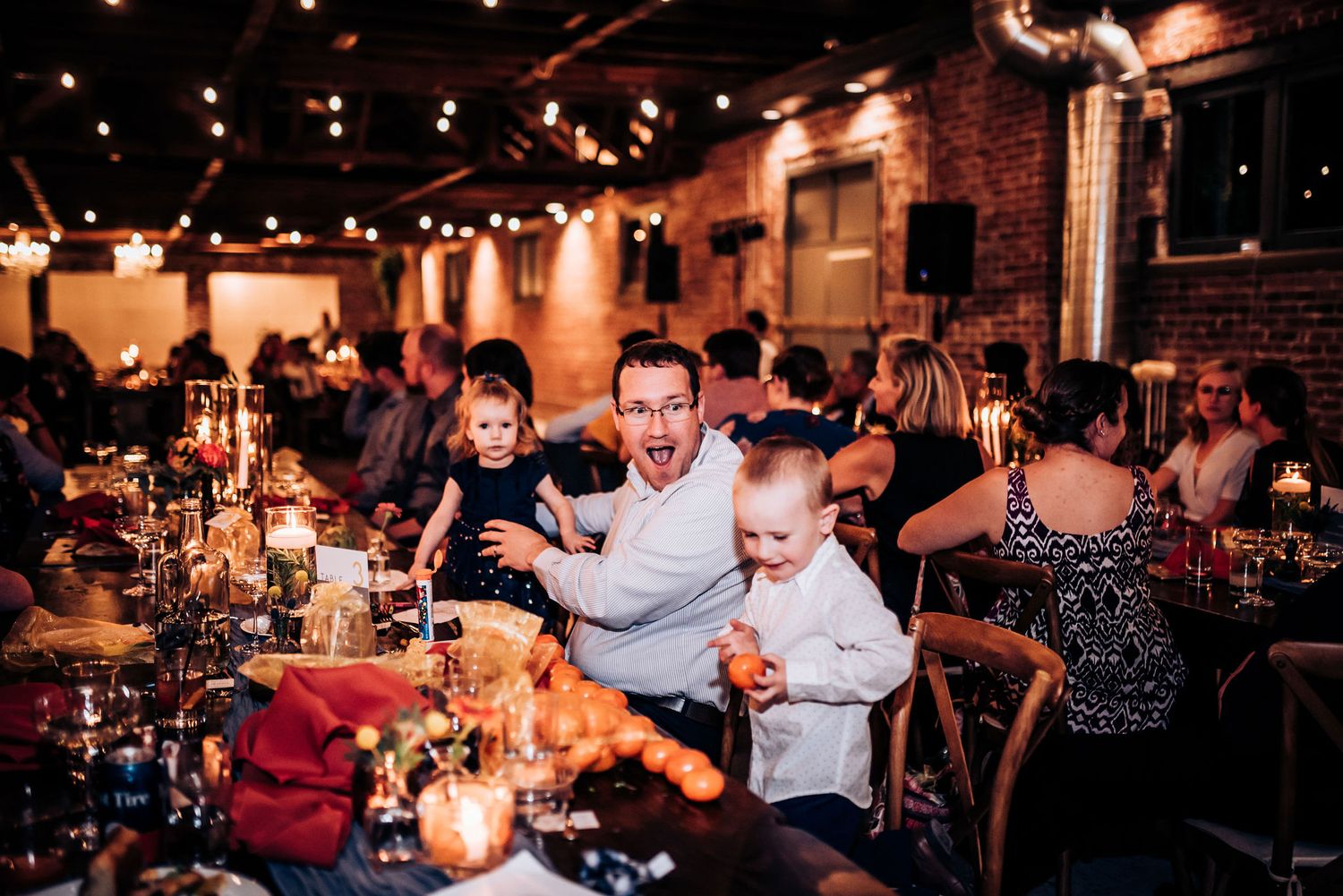 Lively celebration at a restaurant with guests enjoying drinks under ambient lighting.