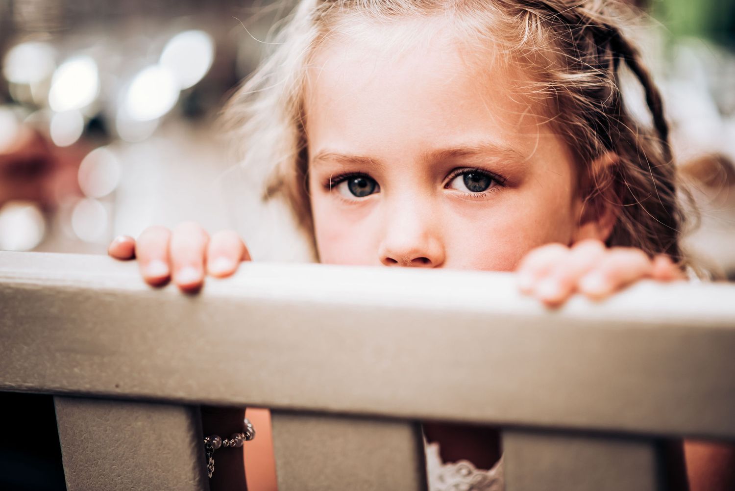 Young child peeking over edge of chair in candid reception moment.