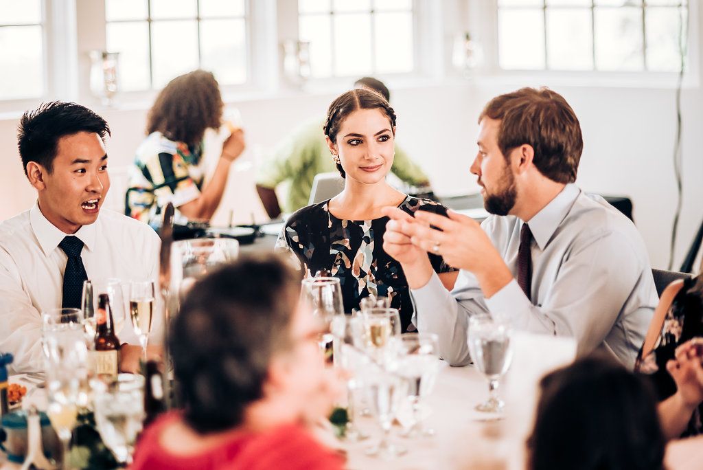 Guests enjoying conversation during an elegant wedding reception dinner.