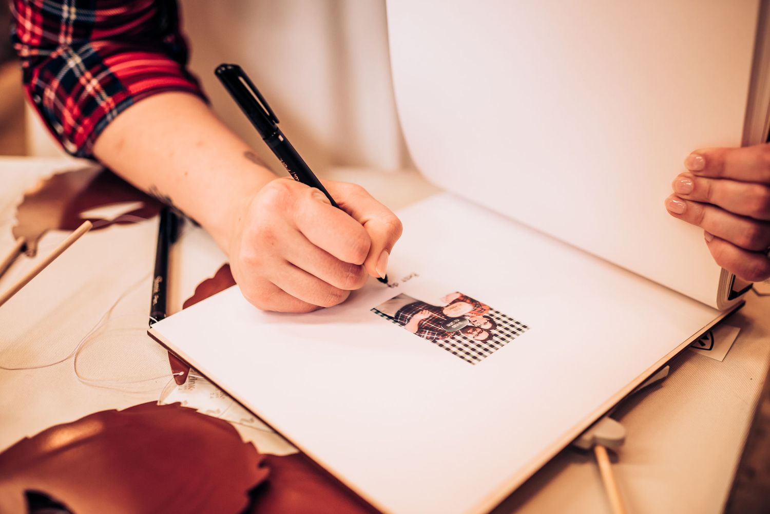 Hand drawing in a guestbook at rustic wedding reception.