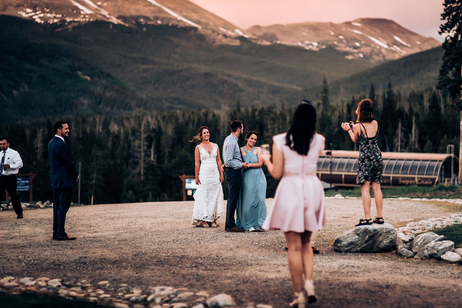 Wedding celebration with mountain vista and evergreen forest in background.
