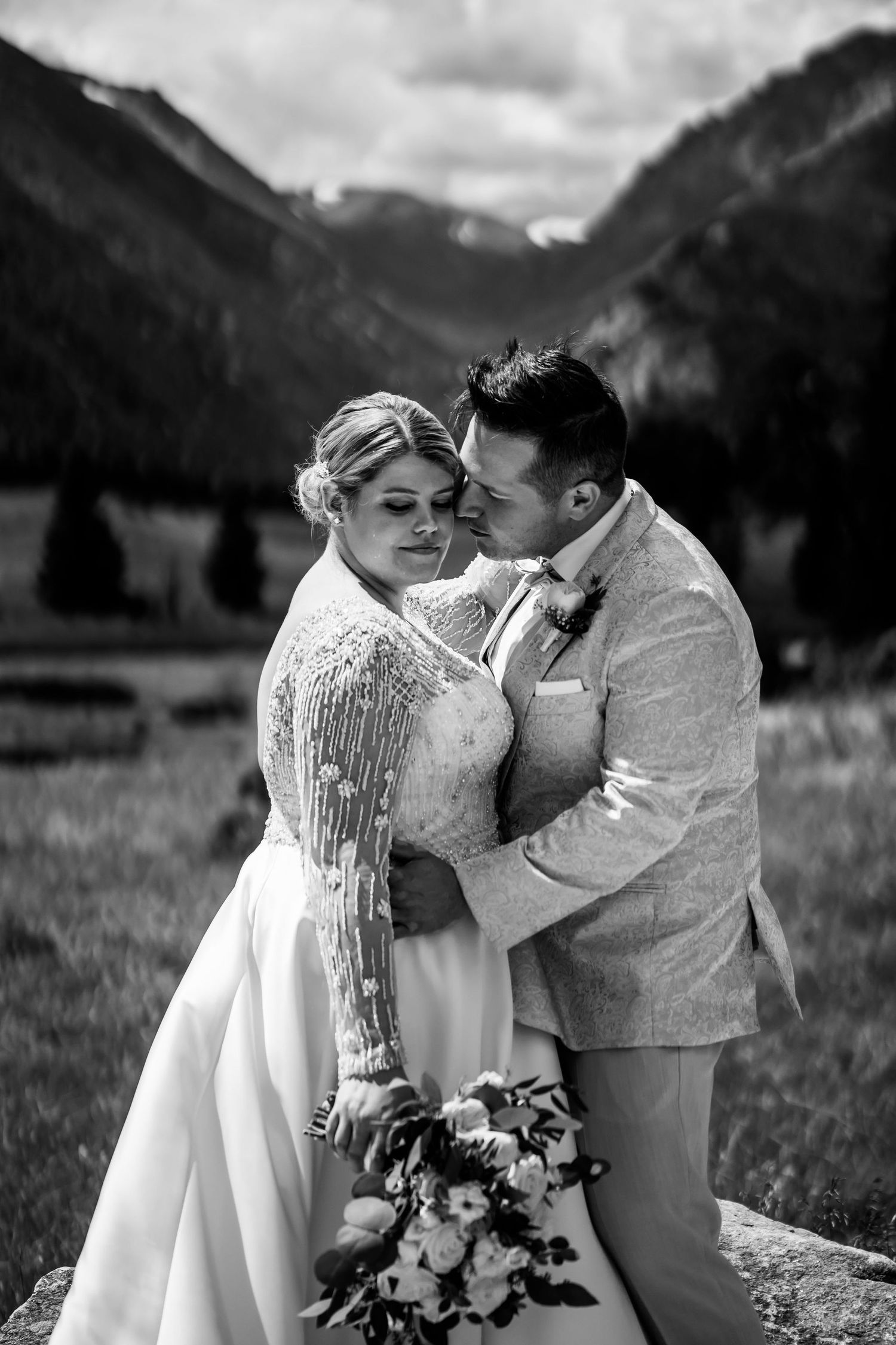 Romantic wedding portrait in black and white with majestic mountain backdrop.