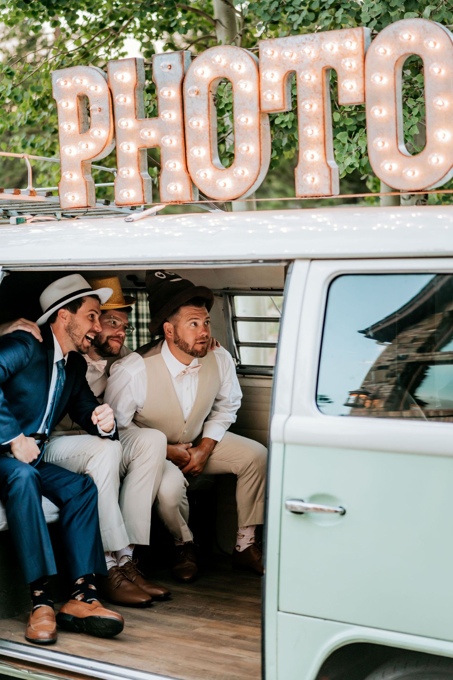Vintage photo booth setup with light-up letters above a classic VW van.