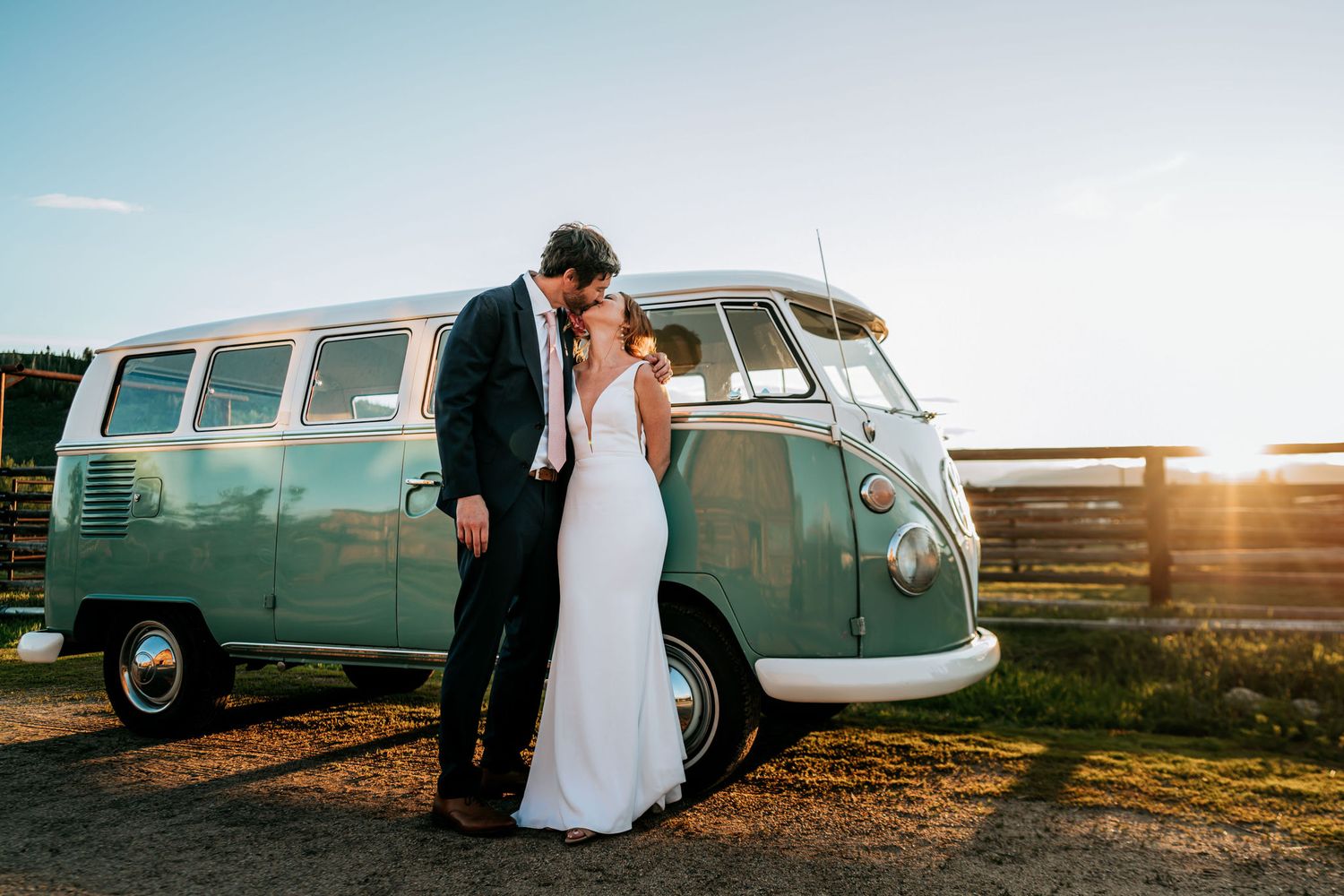 A romantic sunset wedding portrait with a classic mint green VW bus as backdrop.
