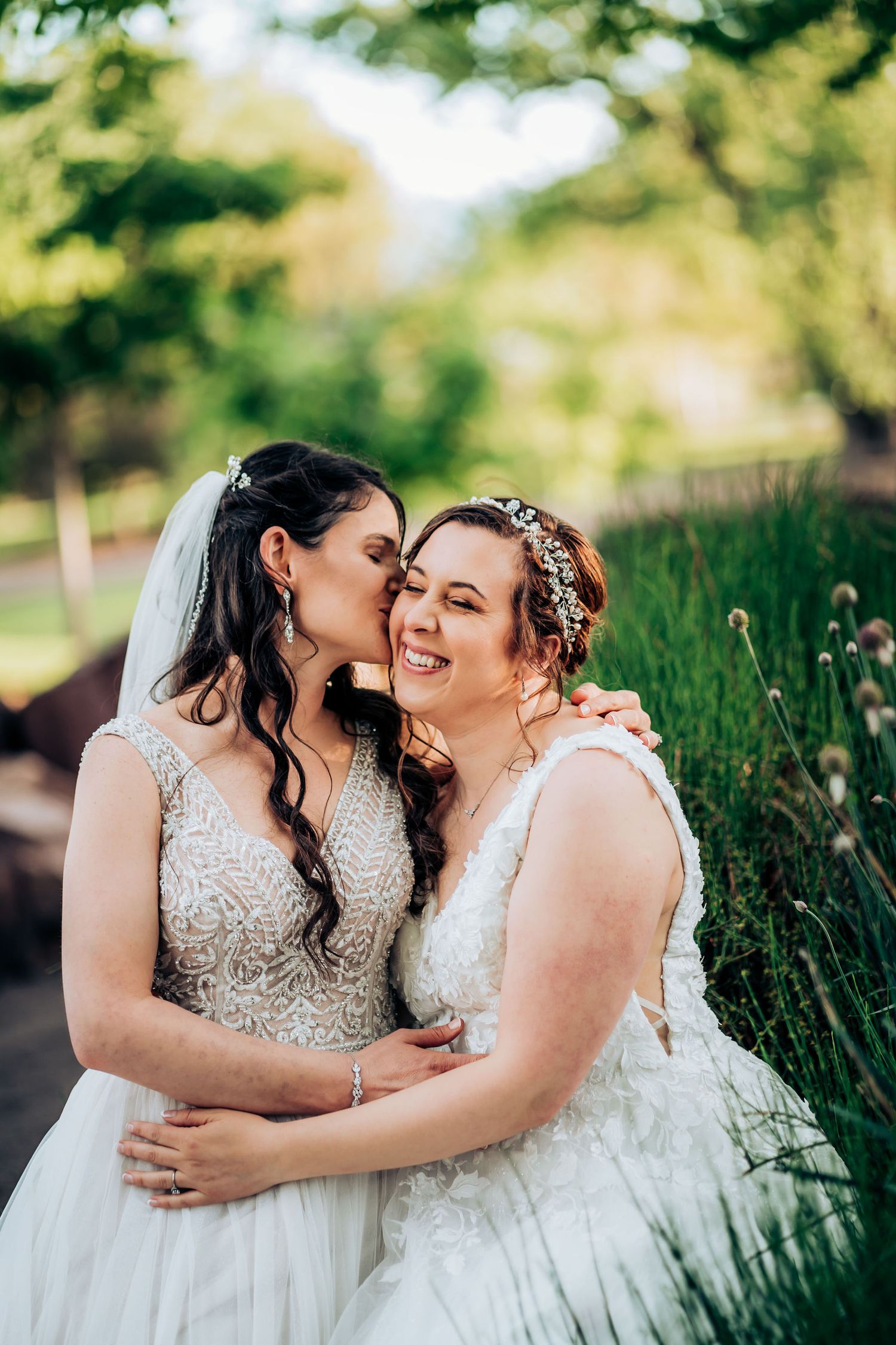 Intimate wedding moment captured outdoors among tall grasses and natural scenery.