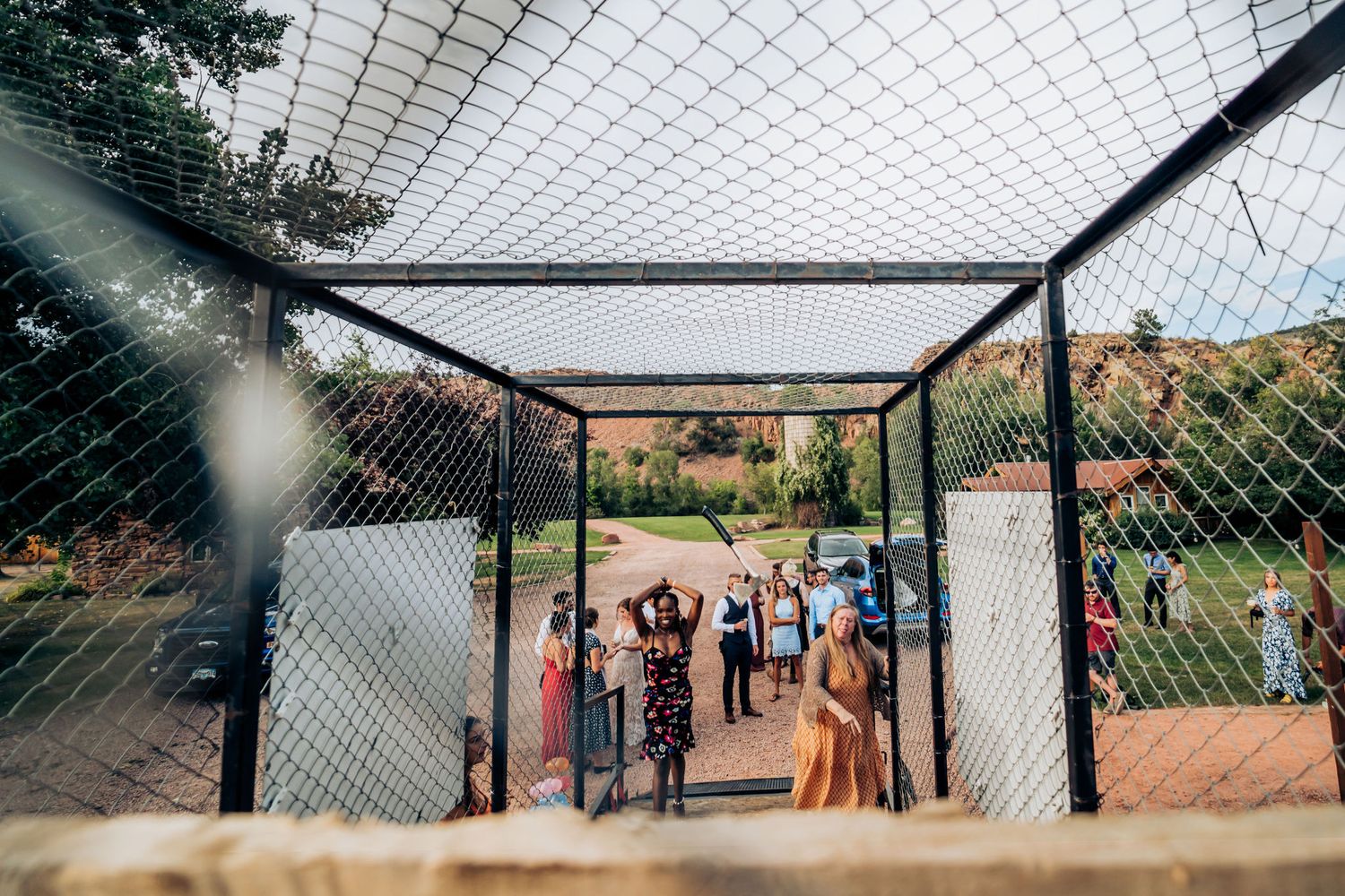 Group of guests gather under a netted canopy outdoors during a celebration event.
