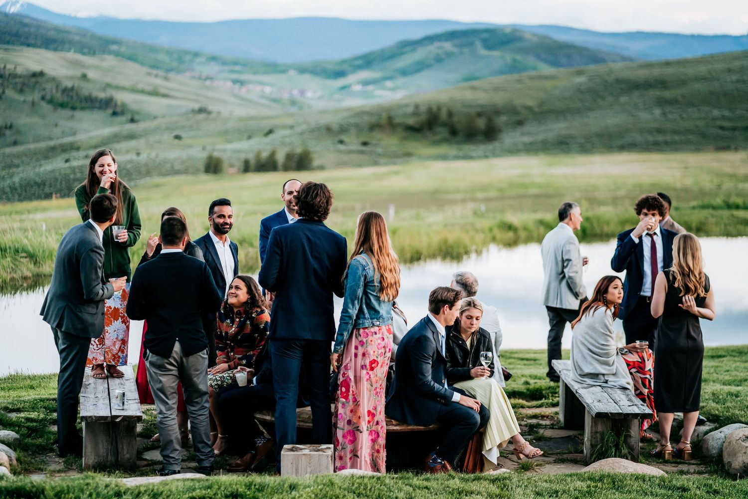 Outdoor reception with guests mingling on stone patio surrounded by mountain views.