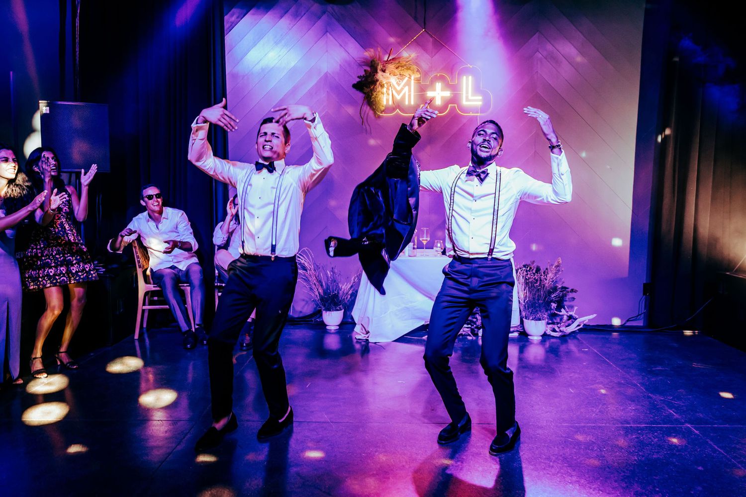 Dynamic dance party scene with colorful stage lighting and people dancing at a celebration event.