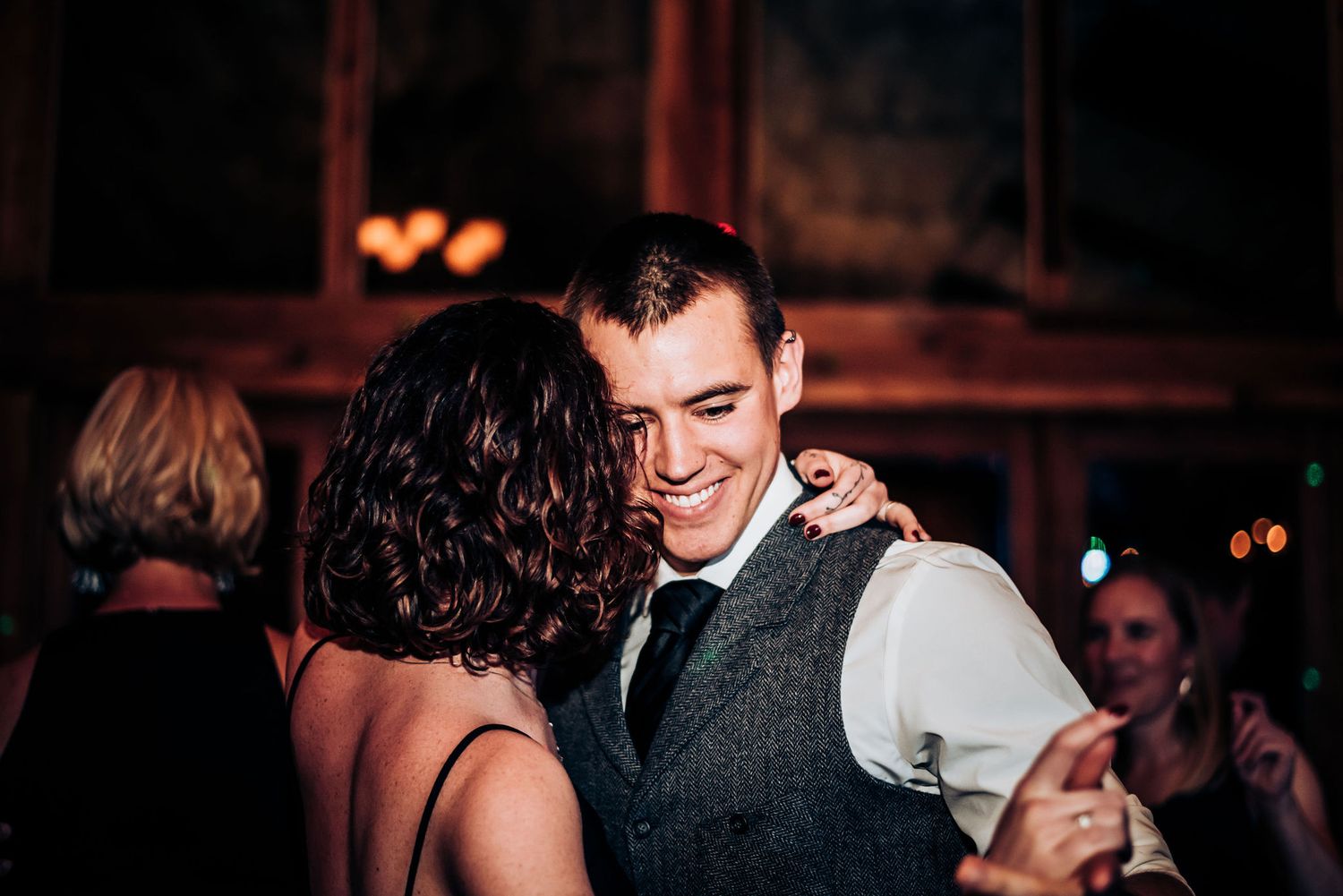 A couple shares an intimate dance moment at an evening wedding reception.