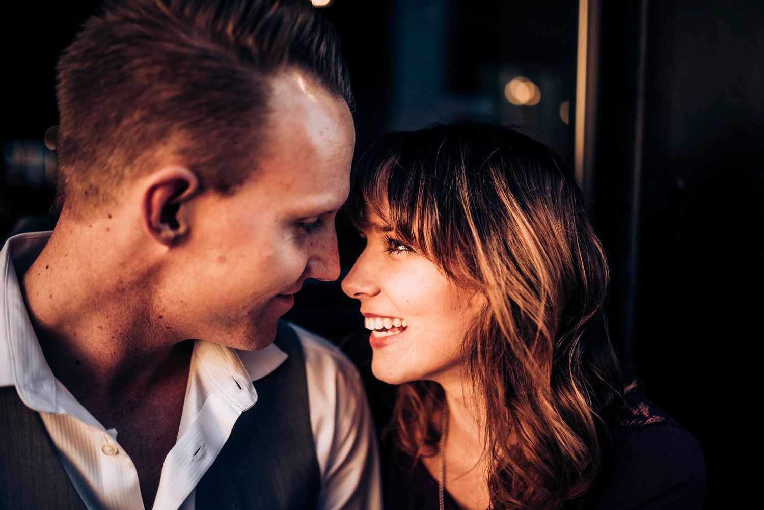 Intimate close-up of couple sharing a joyful moment in evening light.
