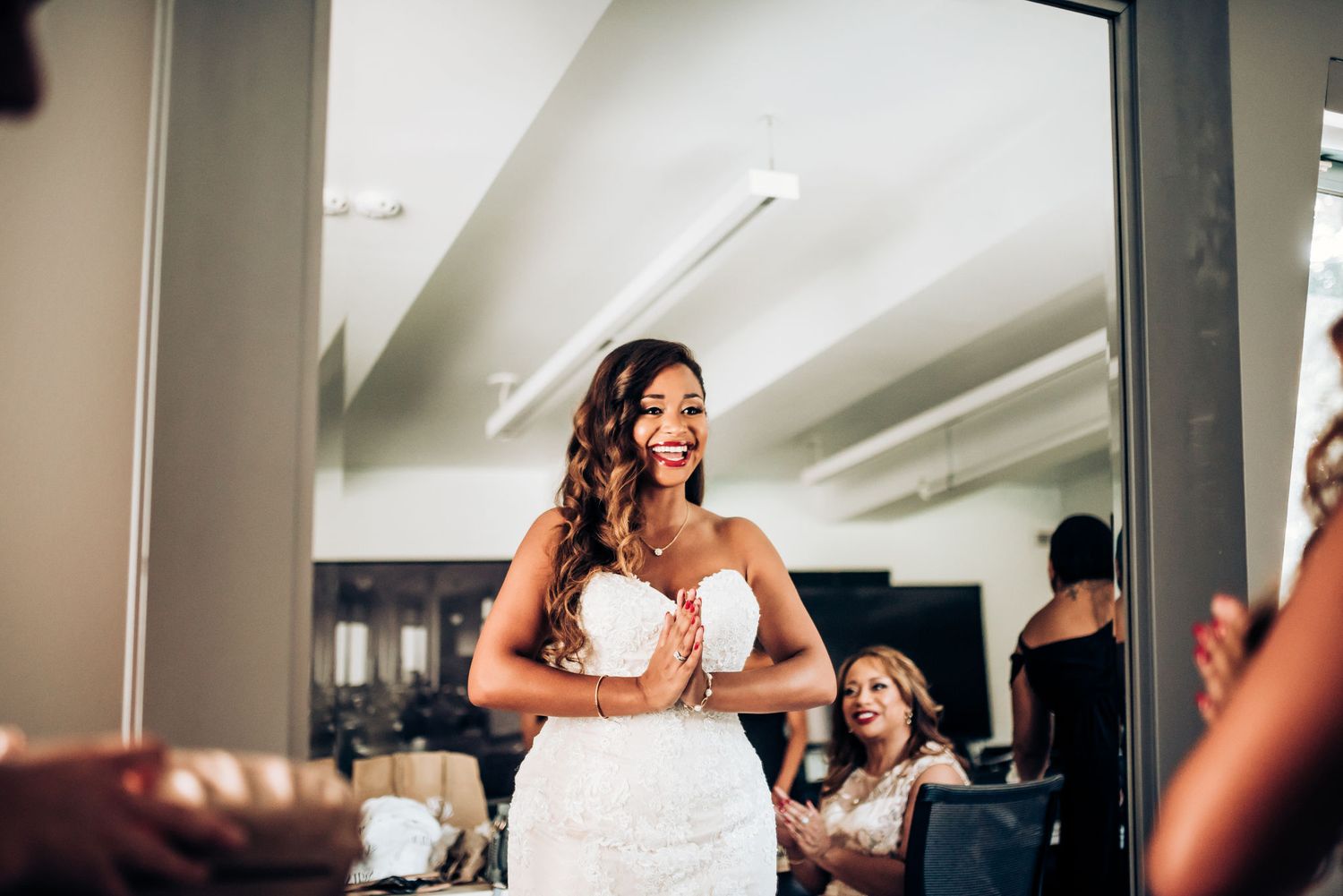 A strapless white wedding dress being fitted in a bridal preparation room.