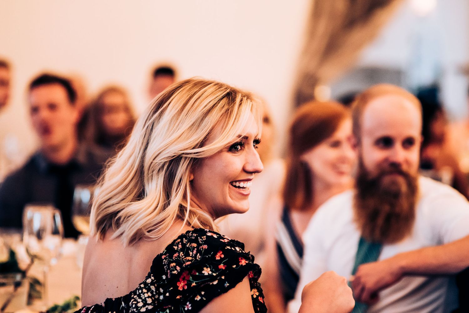 Wedding reception guests enjoy the celebration with smiles and laughter.