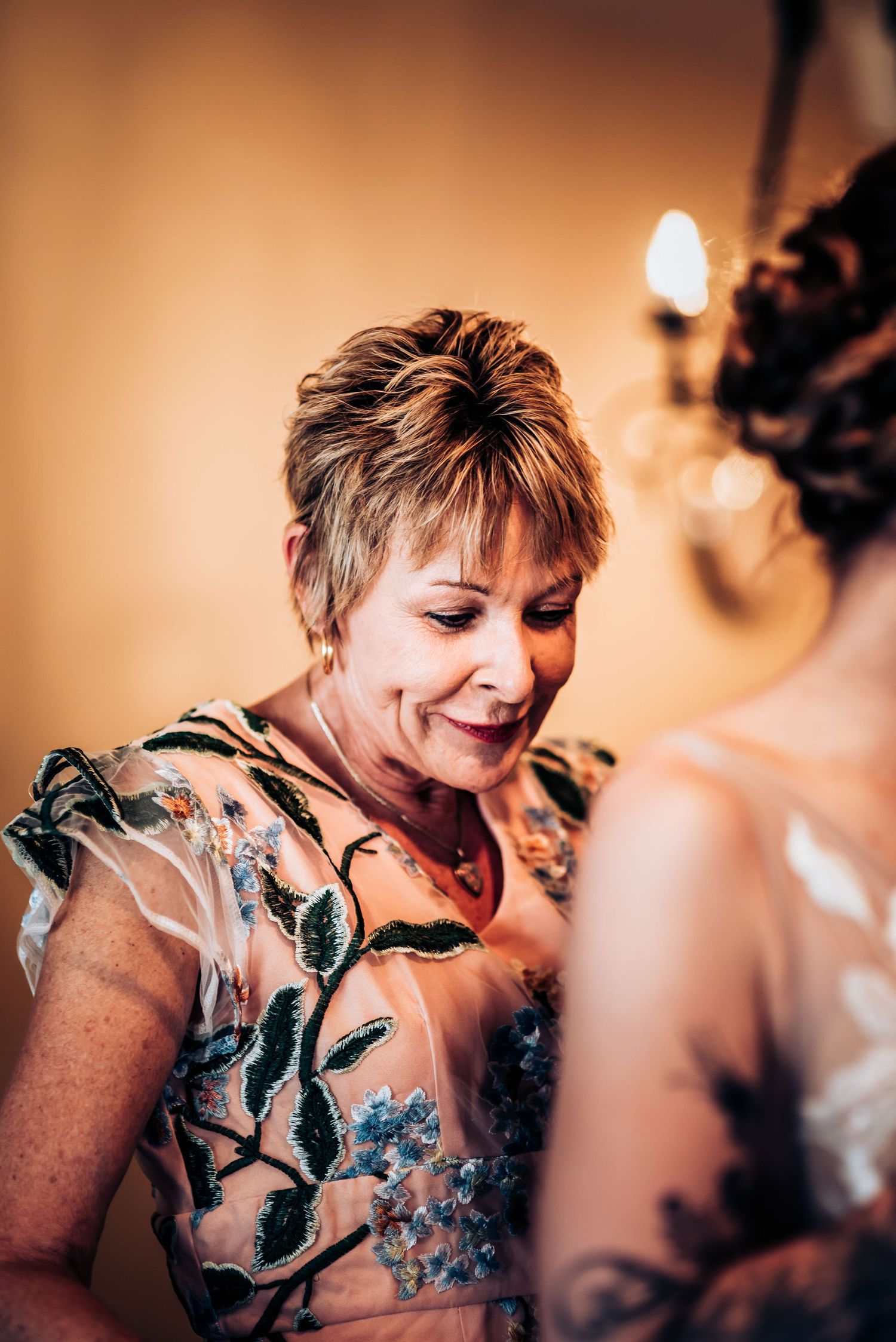 Emotional moment captured during wedding preparations in warm lighting.