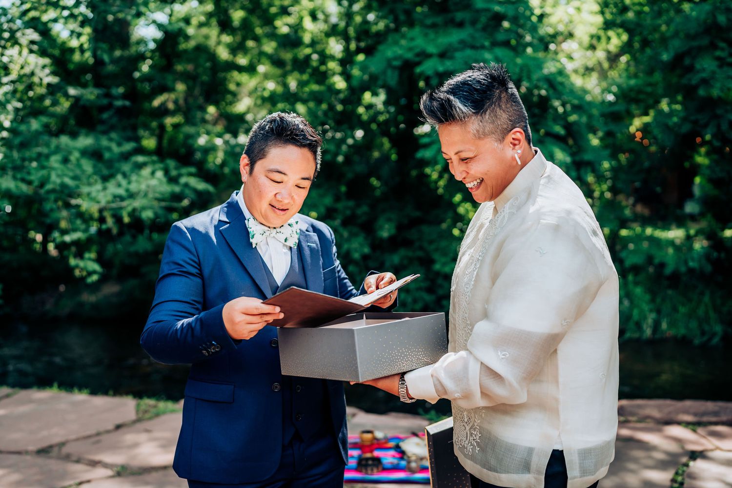 Two people examine the contents of a box together at an outdoor celebration.