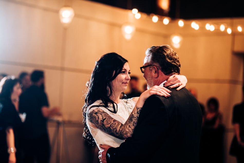A tender moment between a couple during their wedding dance under soft lighting.