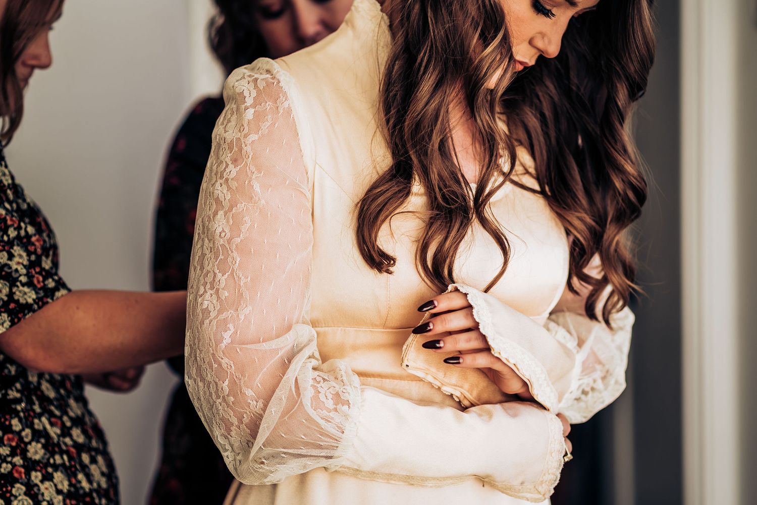 Close up of delicate lace sleeves on an elegant cream-colored wedding dress.