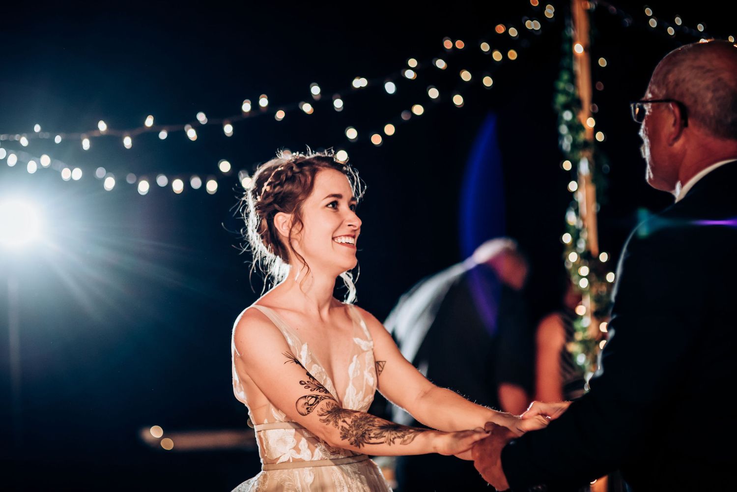 A dancing couple illuminated by bright spotlights during their wedding celebration.