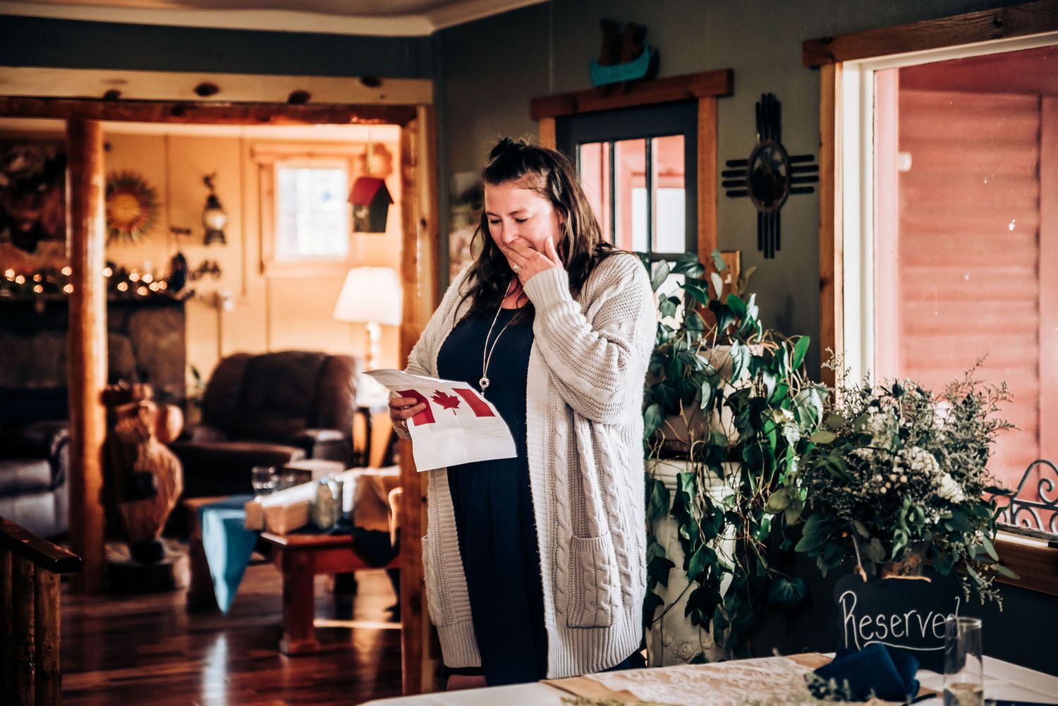 Someone emotional while reading from papers in a rustic wedding venue with natural lighting.