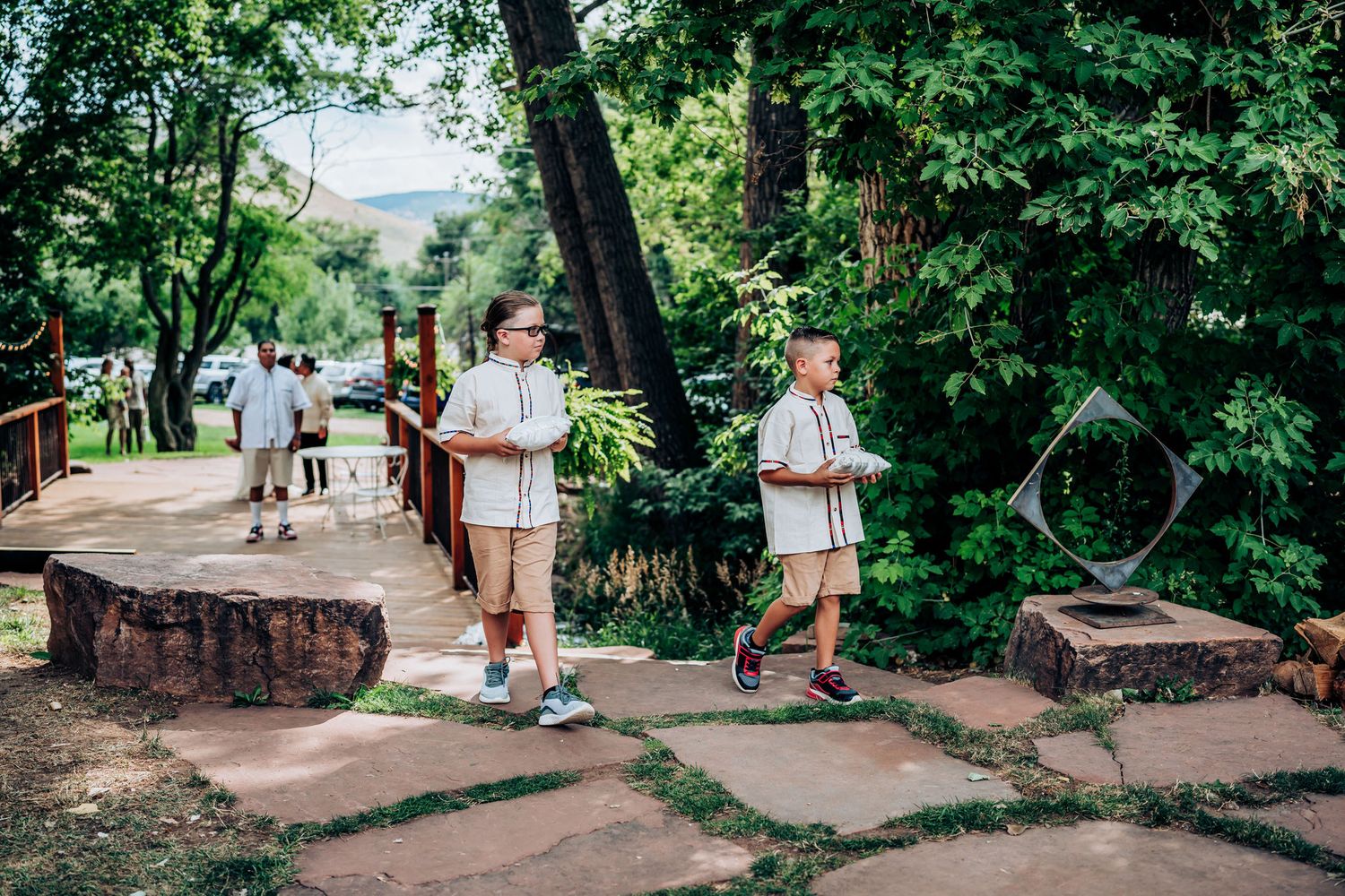 Guests walk along a stone pathway through a lush garden setting.