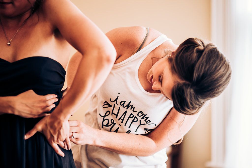 Candid moment of wedding party members laughing together during preparation.