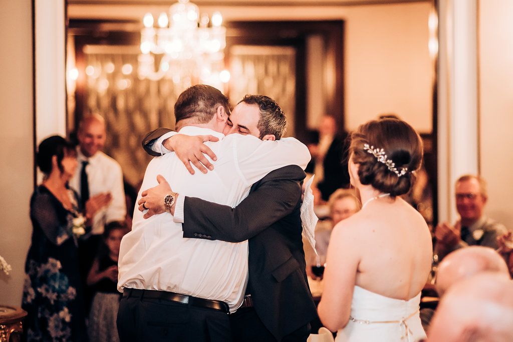 Emotional embrace shared during wedding reception celebration.