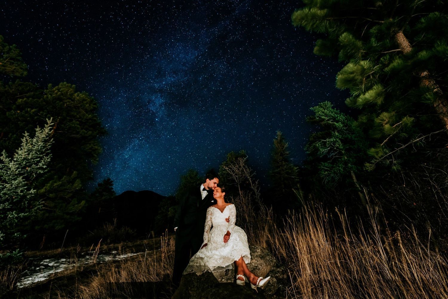 Nighttime wedding photography with starry sky and dramatic lighting.