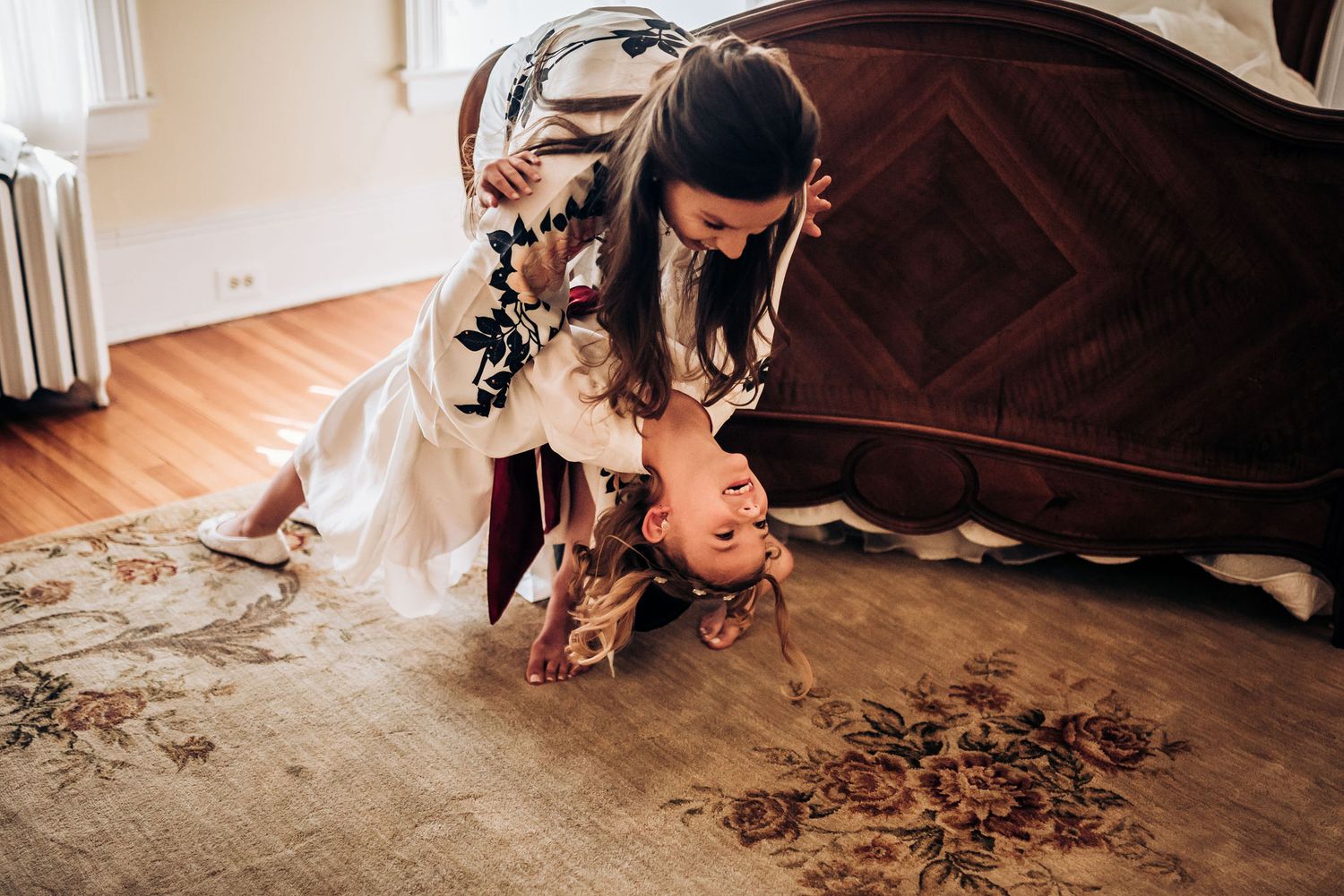 Wedding morning preparations with a robe-clad figure bending down in an elegant bedroom.