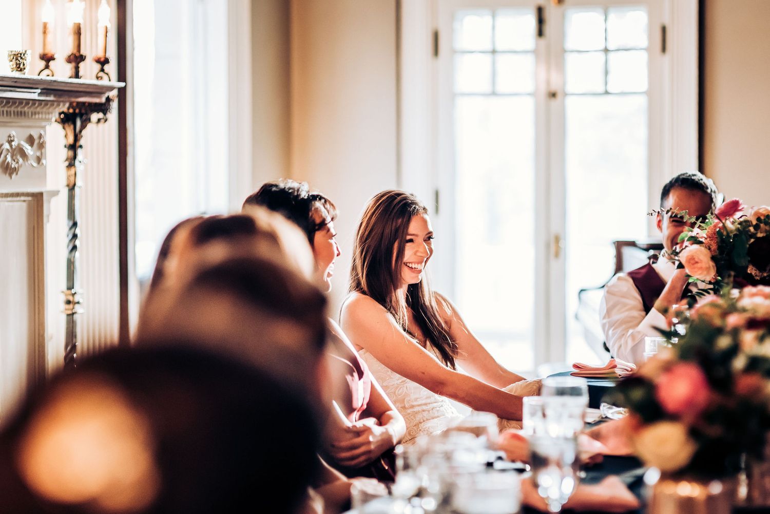 Elegant wedding reception scene with guests seated at decorated dining tables.