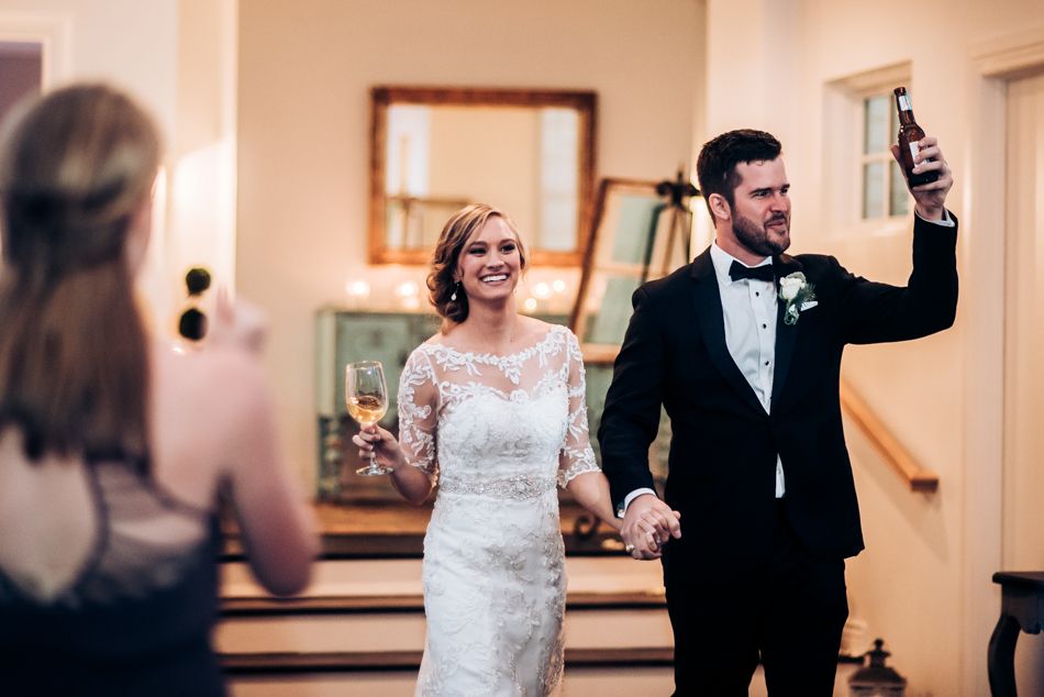 Celebratory moment during wedding reception as couple raises their hands in victory.