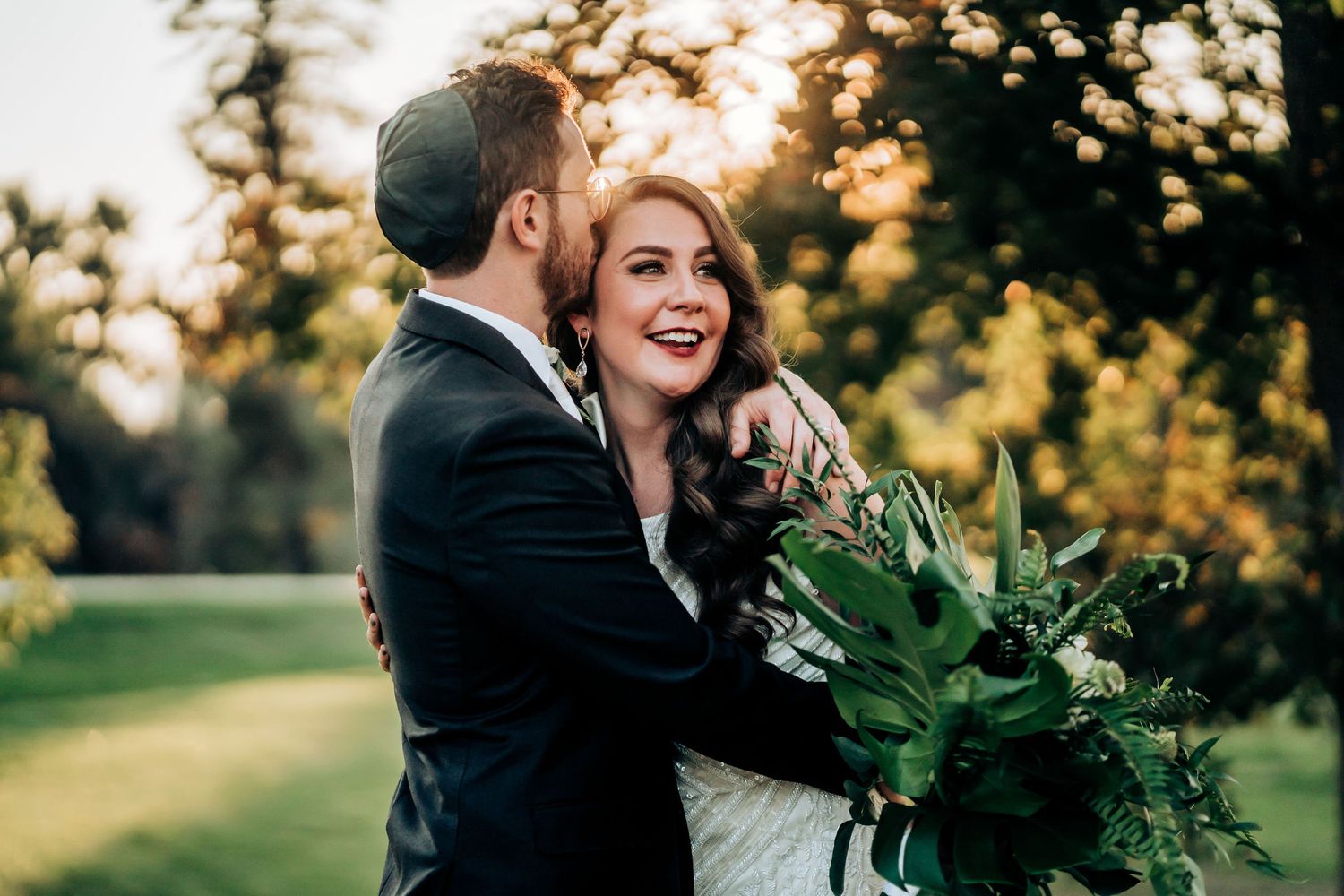 Romantic sunset portrait with lush greenery bouquet in golden evening light.